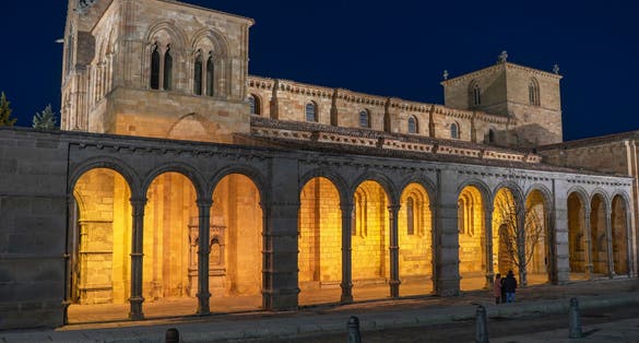 photo of view of Romanesque church of San Vicente illuminated at night in the capital of Avila.