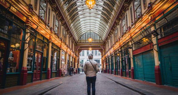 Photo of a man looking at Leadenhall Market in London, UK.