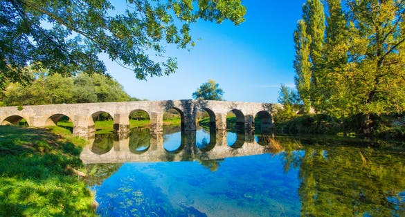 photo of view of Croatian countryside, old stone bridge over the Dobra river in Novigrad, Karlovac county, beautiful landscape