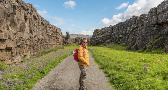 photo of Caucasian hiker on the hiking route between Lögberg and Drekkingarhylur in amazing Iceland. Geology, volcanic, summer, tourist, tourism, destination, visit, europe, nordic, north, golden circle.