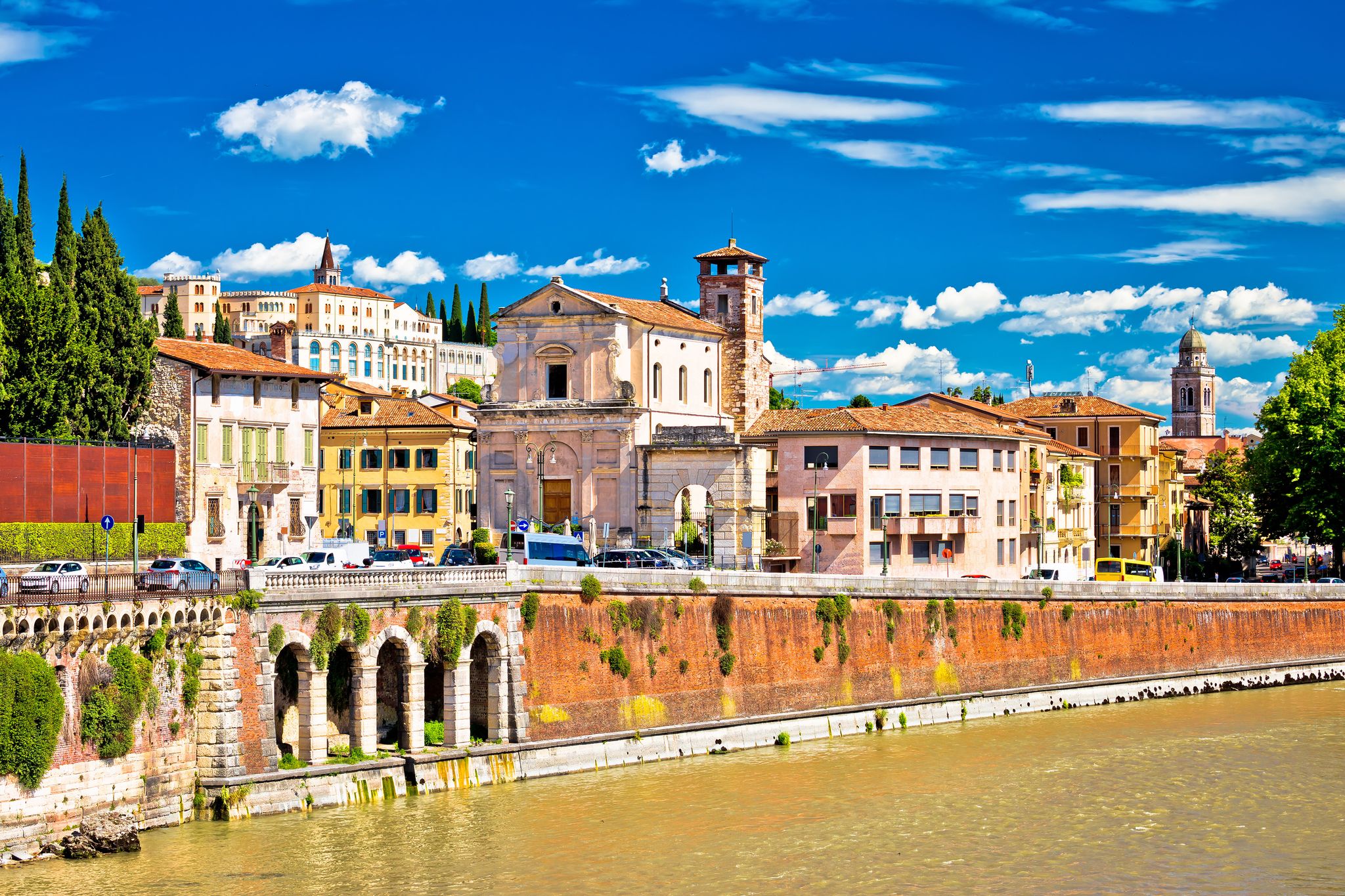 Photo of aerial view of Verona historical city centre, Ponte Pietra bridge across Adige river, Verona Cathedral, Duomo di Verona, red tiled roofs, Veneto Region, Italy.