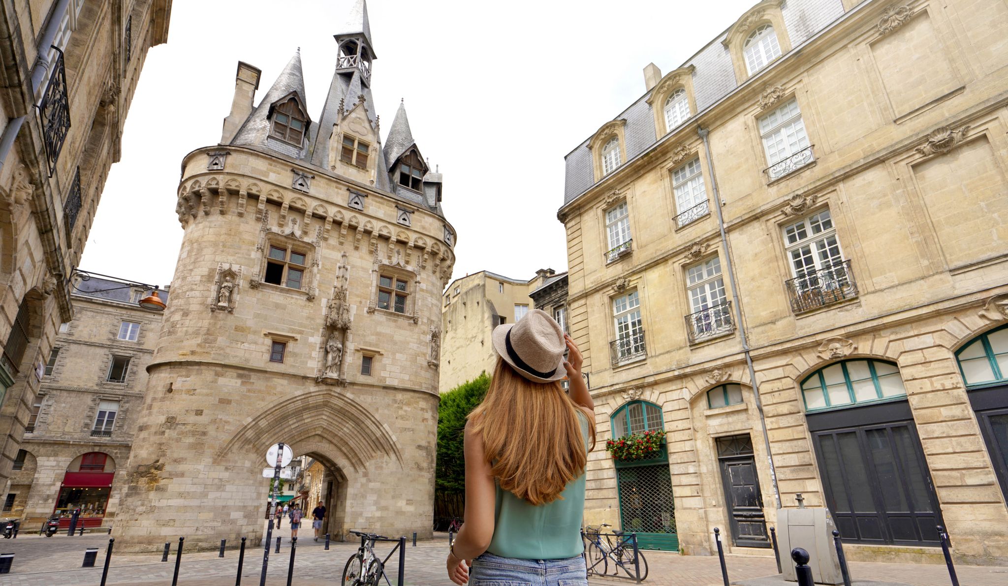 Tourism in Bordeaux, France. Traveler girl walking in Bordeaux discovering Porte Cailhau a medieval gatehouse of the old city walls.jpg