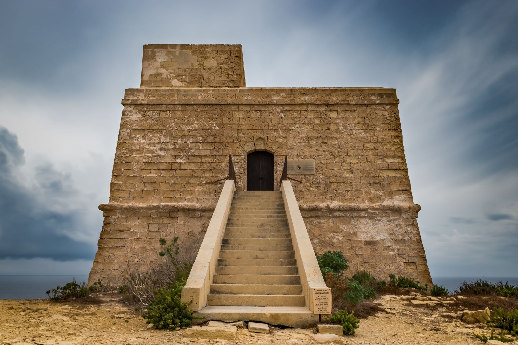 Dwejra bay Tower or watchtower. Qawra. Lascaris towers. Long exposure shot on a bad weather day. Low angel view. Horizontal.