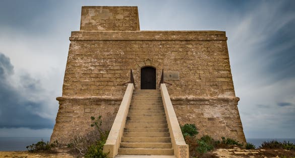 Dwejra bay Tower or watchtower. Qawra. Lascaris towers. Long exposure shot on a bad weather day. Low angel view. Horizontal.