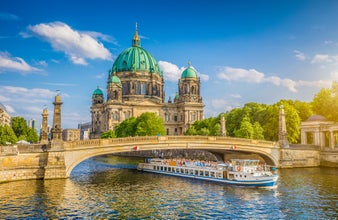 beautiful view of historic Berlin Cathedral (Berliner Dom) at famous Museumsinsel (Museum Island) with excursion boat on Spree river in beautiful sunset in summer, Berlin.