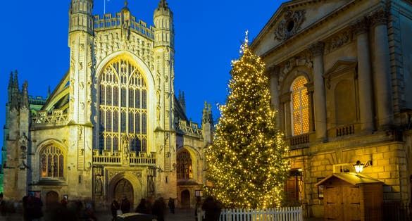 Photo of historic Bath Abbey and roman baths building at night in Bath Old town center, England.