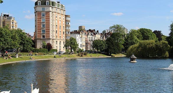 photo of view of Ixelles pond in October. Church reflection in water. Sunny autumn afternoon, Ixelles, Belgium.