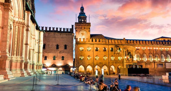 photo of Colorful spring sunset on the main square of City of Bologna with Palazzo d'Accursio and facade of Basilica di San Petronio. Great cityscape of Bologna, Italy, Europe. Traveling concept background.