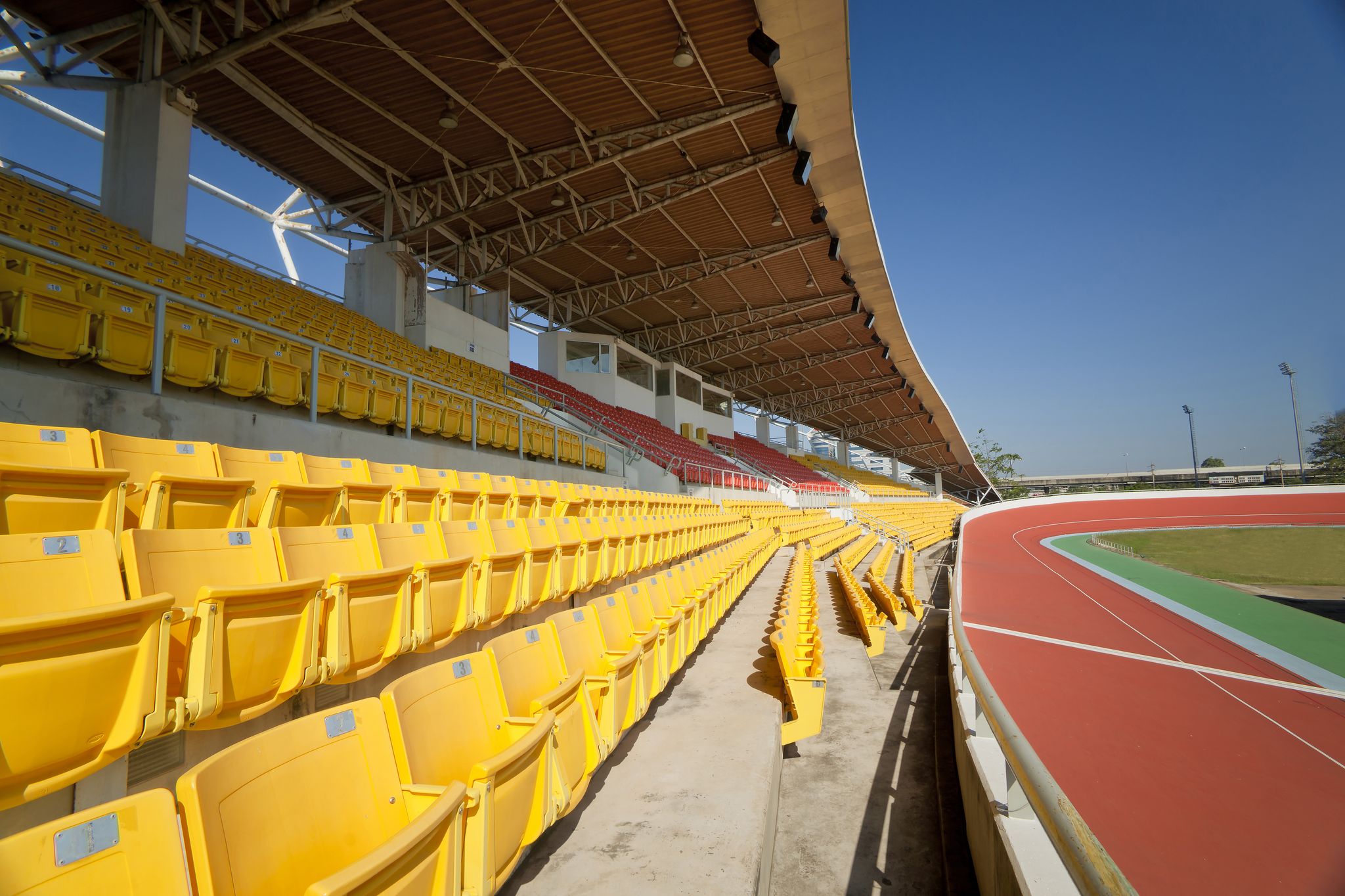 Yellow seats at the Orange Vélodrome overlooking part of the track and the green field..jpg
