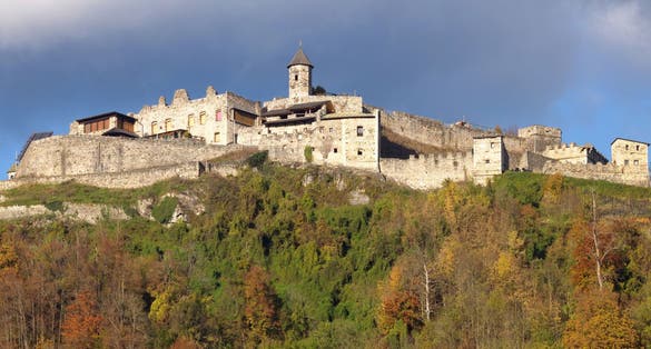 The old medieval castle of Landskron in Villach/Austria located on top of a hill surrounded by a forest.