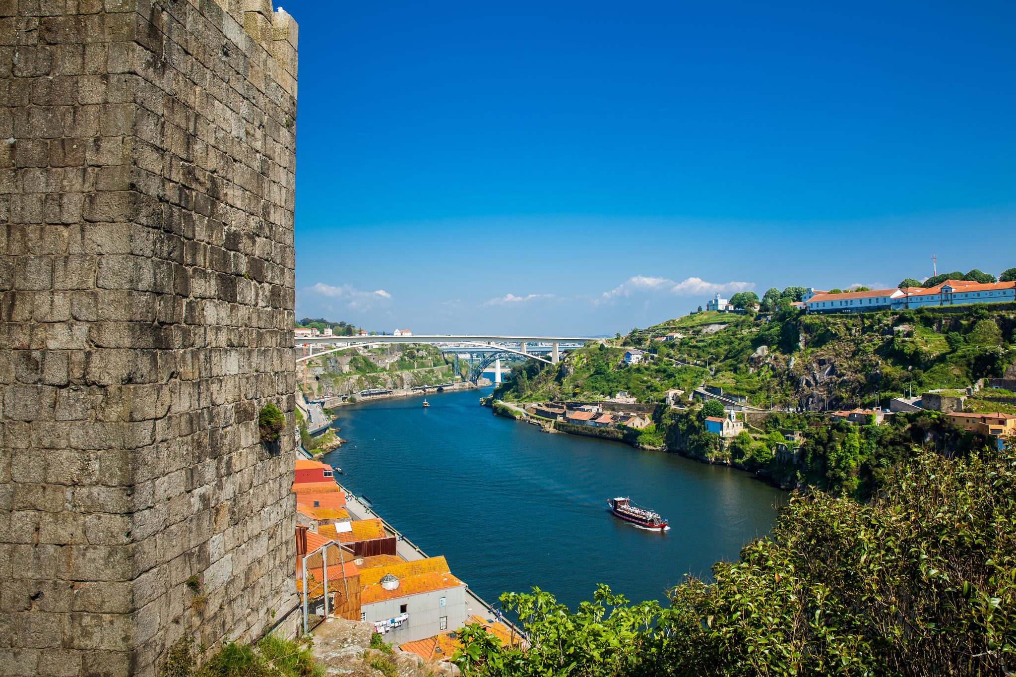Photo of Fernandine Wall of Porto and the Douro River next to the Dom Luis I Bridge in a beautiful sunny day.