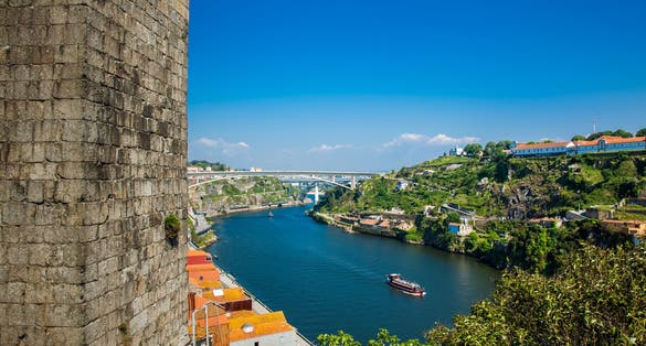 Photo of Fernandine Wall of Porto and the Douro River next to the Dom Luis I Bridge in a beautiful sunny day.