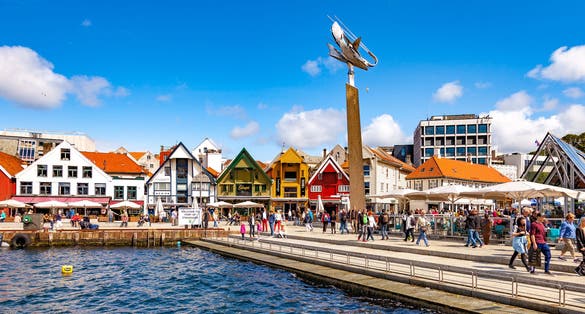 Photo of lots of tourists walking, shopping and sightseeing city center in Stavanger, Norway.