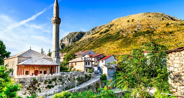 Mostar, Bosnia and Herzegovina. Morning summer light on the Old City with medieval Ottoman Mosque and minaret.