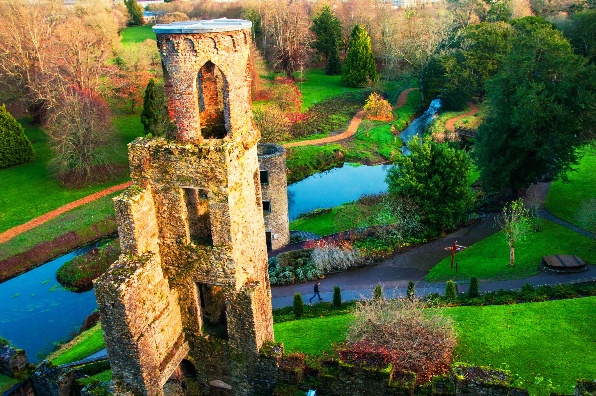 photo of Blarney, Ireland. Autumn in Ireland. Aerial view of Blarney Castle tower in Ireland. Forest and fields at the background .
