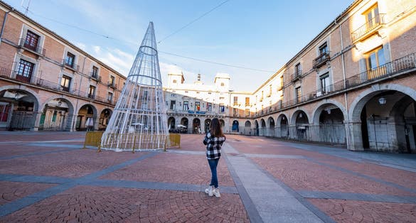 photo of view of Caucasian woman, back view, Avila's winter. Casual elegance, historic charm, exploration delight.