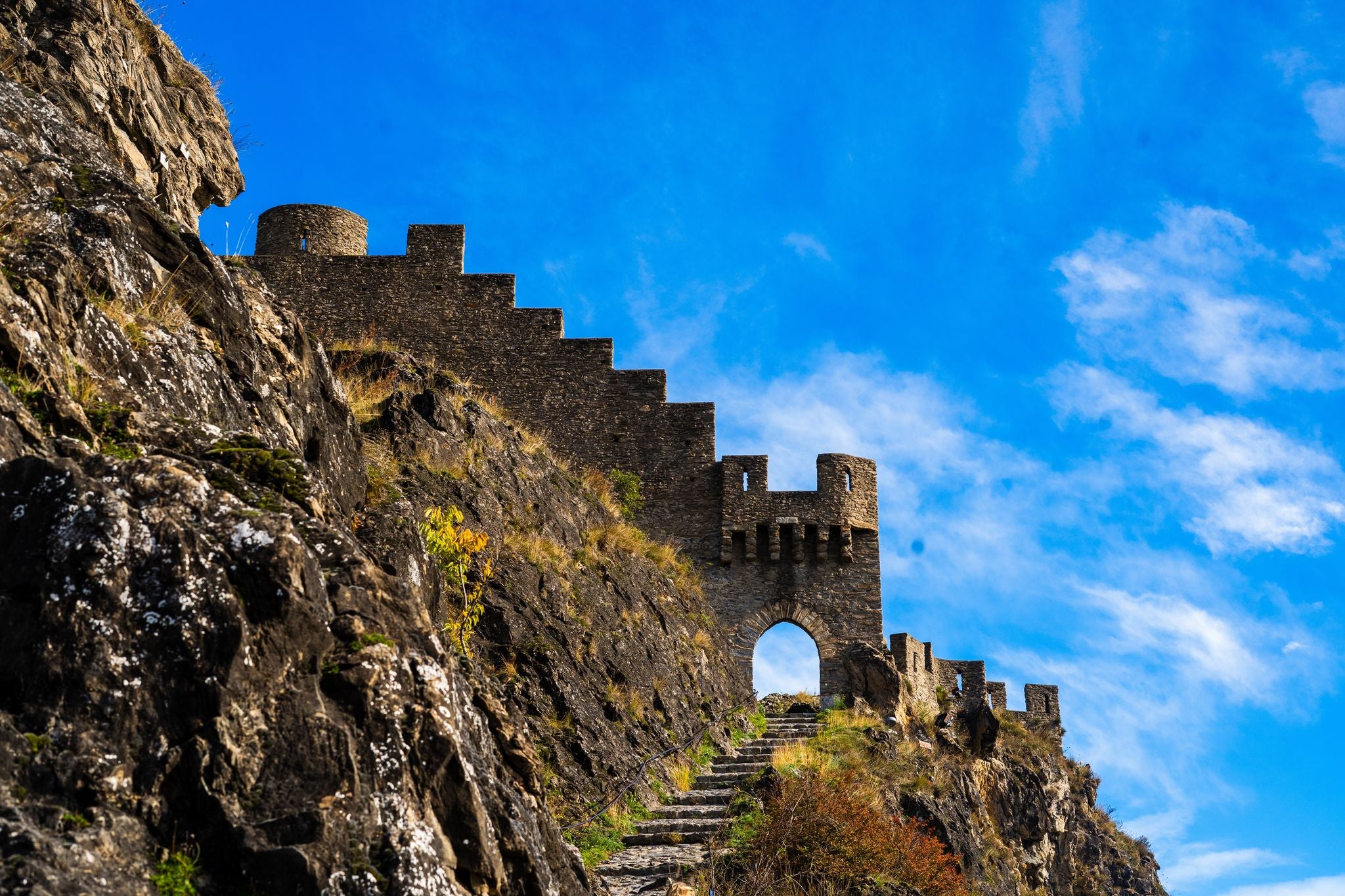 Entrance door and wall of the ruins of Photo of Tourbillon castle and Sion hill and city panorama in background in Sion Valais Switzerland