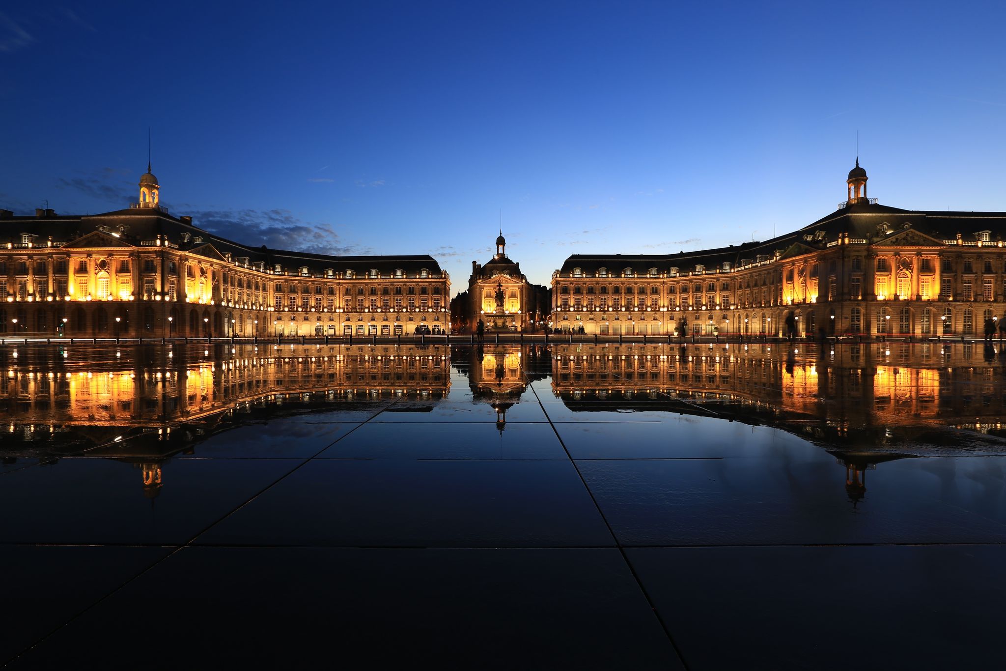 photo of Place de la Bourse in Bordeaux with its reflections in water mirror in a beautiful summer night in France.