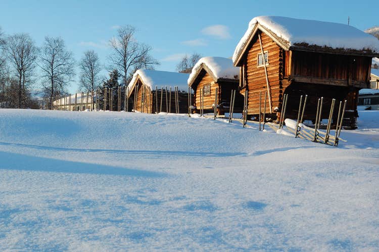 photo of winter landscape with ski slope, village and blue sky in Geilo ski resort, Norway.