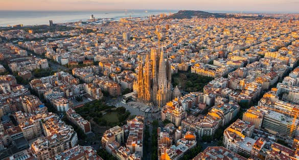 Photo of aerial view of Barcelona Eixample residential district and Sagrada Familia Basilica at sunrise.