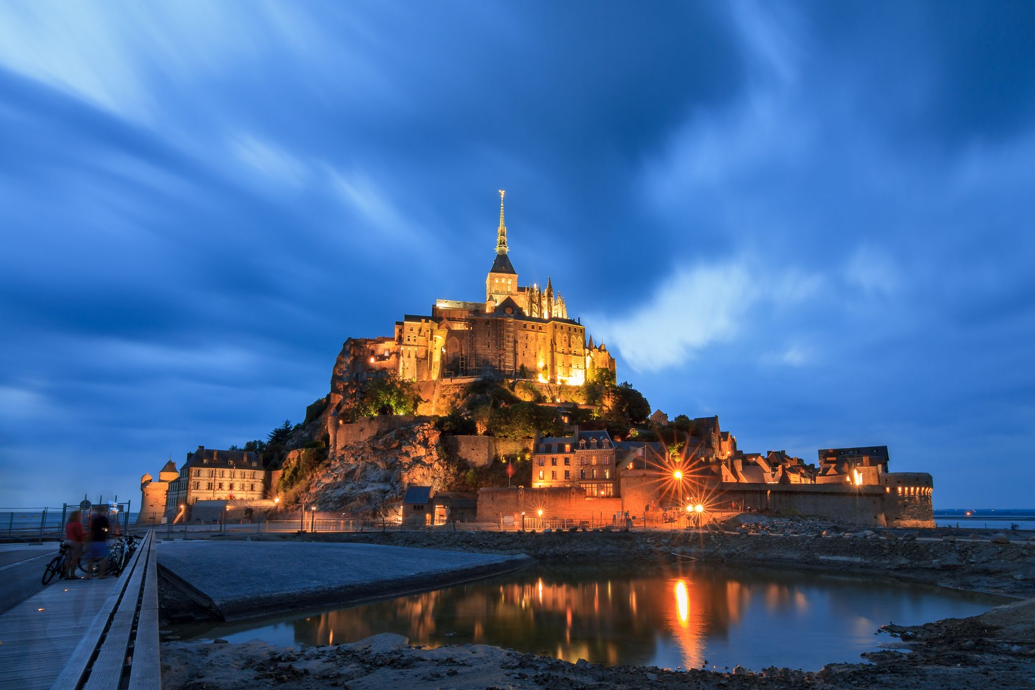 Photo of beautiful view of historic landmark Le Mont Saint-Michel at night in Normandy, France.