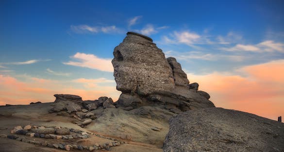 Photo of Sunset at Romanian Sphinx, natural rock formation and geological phenomenon formed through erosion in Bucegi Natural Park, Carpathian Mountains, Romania.