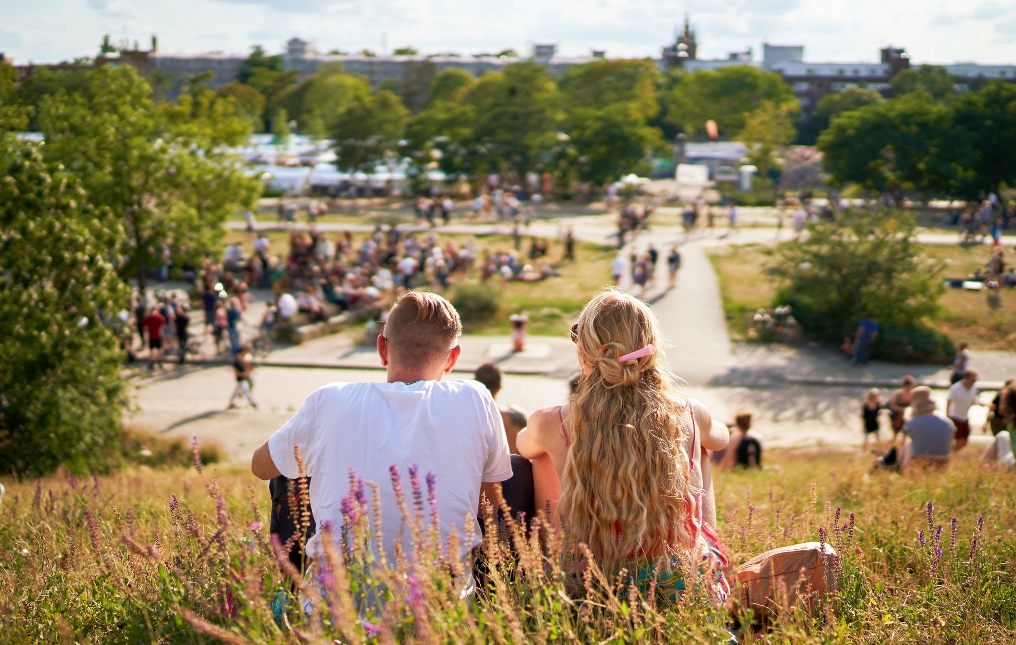 photo of people in park blurry in crowded Park (Mauerpark) on a sunny summer Sunday in Berlin, Germany.
