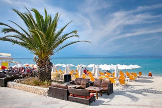 Photo of beautiful Polychrono beach with sunbeds and umbrellas on Kasandra peninsula, Halkidiki, Greece.