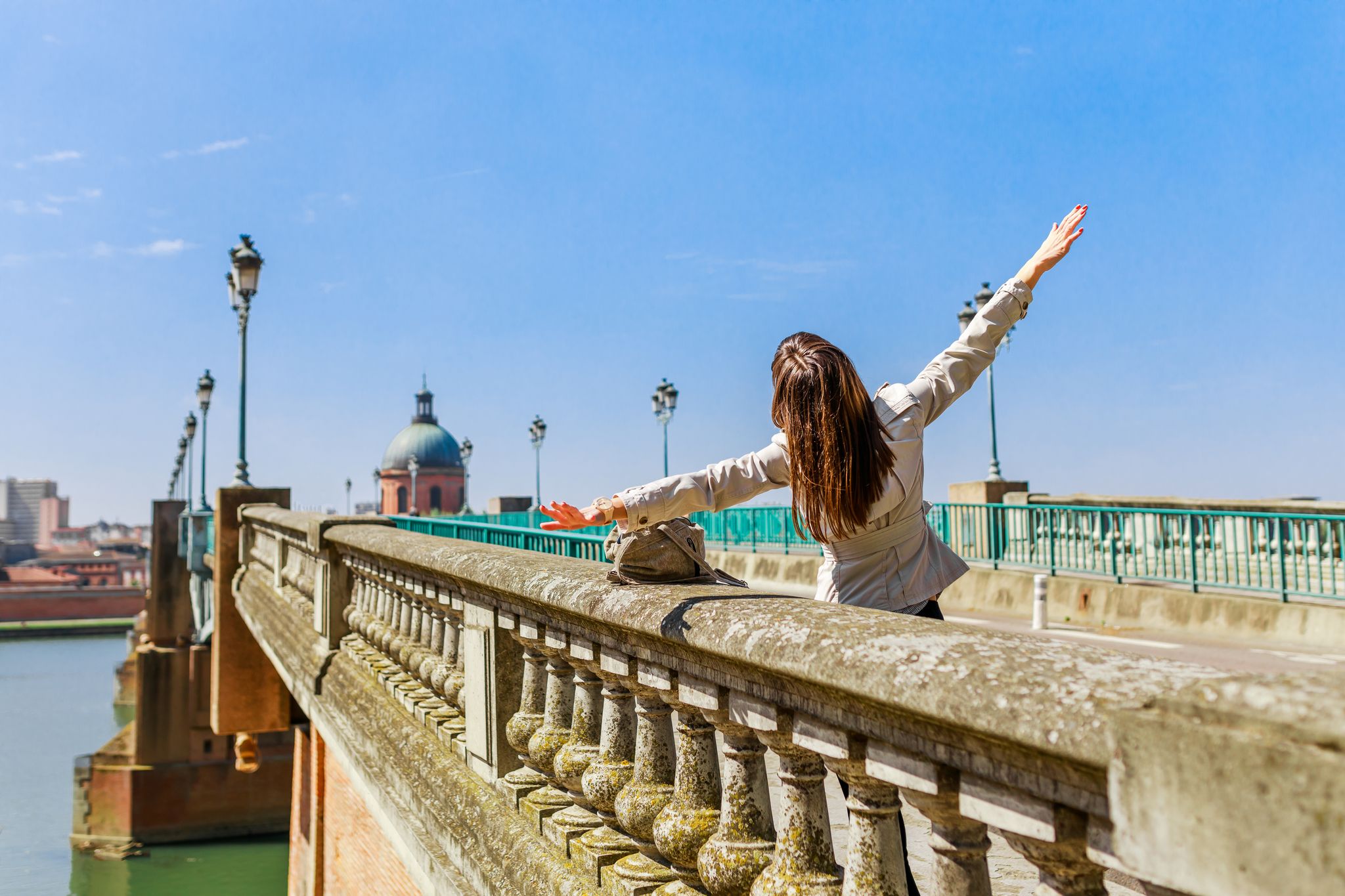 photo of tourist woman on Pont Saint-Pierre in French ancient town Toulouse and Garonne River in France.