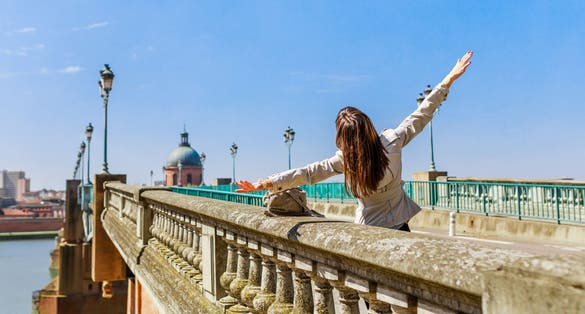 photo of tourist woman on Pont Saint-Pierre in French ancient town Toulouse and Garonne River in France.