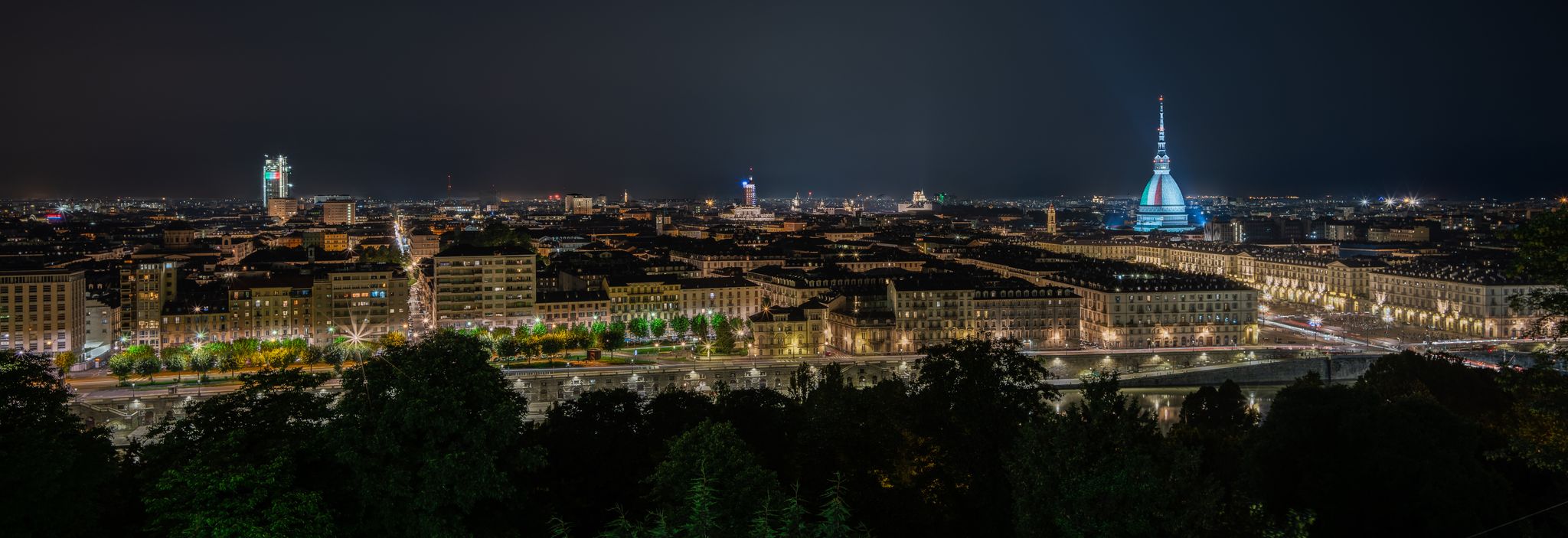 photo of Turin/Italy - May 2020: a wide angle night shot of Turin Landscape; the colours of the Italian flag were shown on the dome of the Mole Antonelliana.