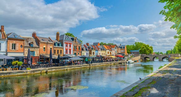 Amiens cityscape old town, promenade Quai Belu of Somme river with restaurants, traditional houses and Pont du Cange stone bridge in historical city centre, Hauts-de-France Region, Northern France