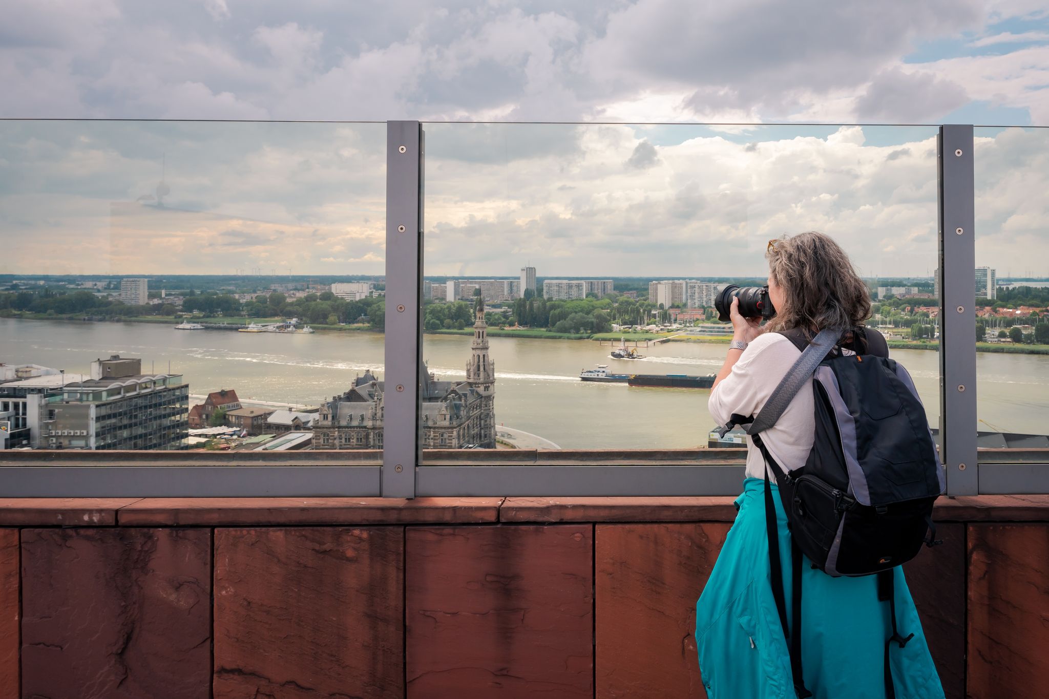 Photo of tourist taking pictures on the roof of the MAS (Museum aan de Stroom). It is a museum located along the river Scheldt in the Eilandje district of Antwerp, Belgium.