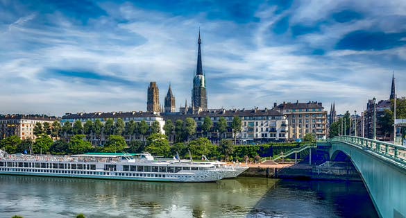 Photo of view from the seafront of Saint-Sever, at the pier of tourist ships and the Cathedral of Rouen Notre Dame. Rouen, Normandy, France.