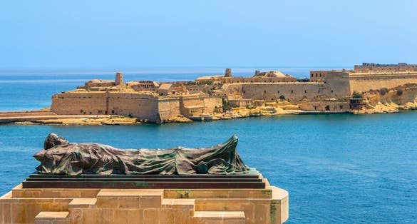 The Siege Bell monument with Fort Ricasoli in the background.