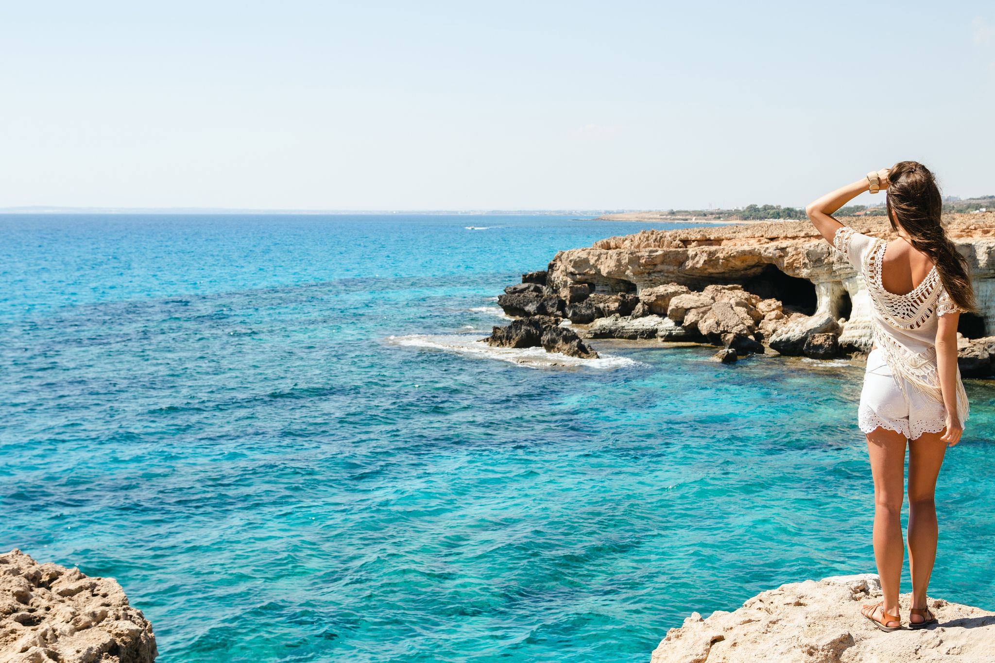 Photo of young woman looking on the stunning views from the famous Cape Greco viewpoint, Cyprus.