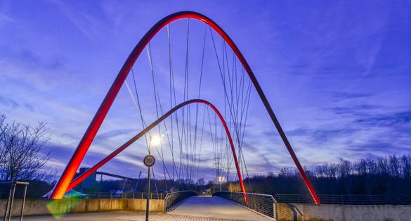 Photo of public park with an illuminated bridge in Gelsenkirchen at night, Germany.