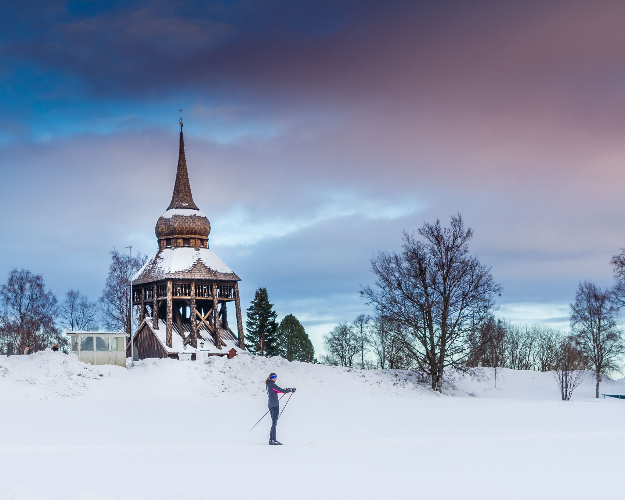 photo of a girl skiing in front of Frösö Church in winter in Sweden.