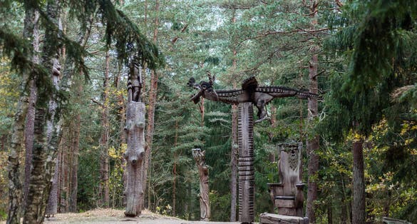 photo of old wooden sculpture in the forest, a knight fights a dragon. Witch hill park, Lithuania.