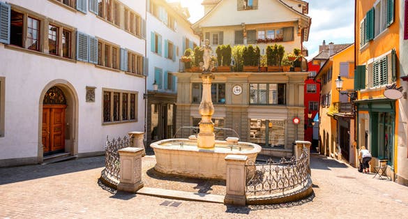 Photo of beautiful small square with fountain in the old town of Zurich city in Switzerland.