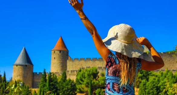 Photo of happy woman visiting Castle of Carcassonne in France.
