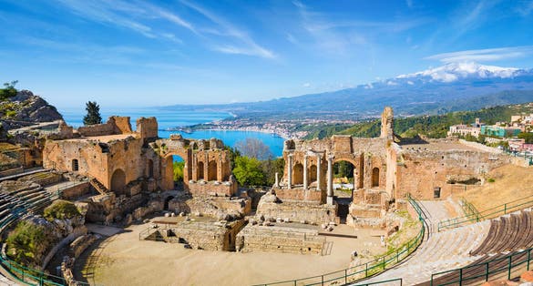 Photo of ruins of Ancient Greek theatre in Taormina located in Metropolitan City of Messina on background of Etna Volcano, Italy.