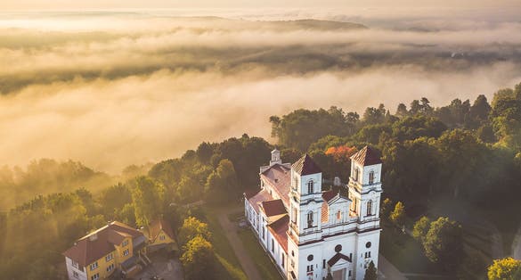 photo of raudondvaris church in the foggy morning, drone aerial view. Raudondvaris is a village in kaunas district, Lithuania.