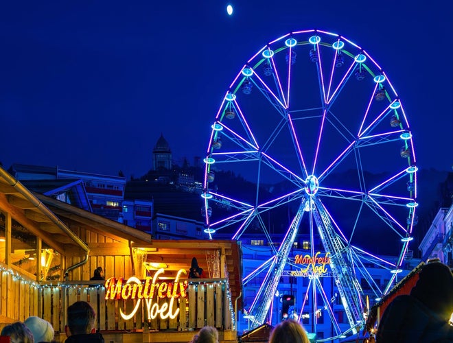 Illuminated Ferris wheel and Montreux Noel Christmas Market at night in Switzerland..jpg