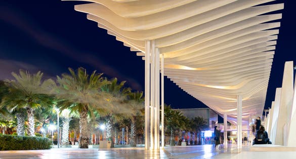 Photo of Great view of Malaga city in the night: promenade of Palmeral de las Sorpresas, beautiful white wawe of Pergola. Happy young people in a modern port area of Malaga, Andalusia, southern Spain, Europa.