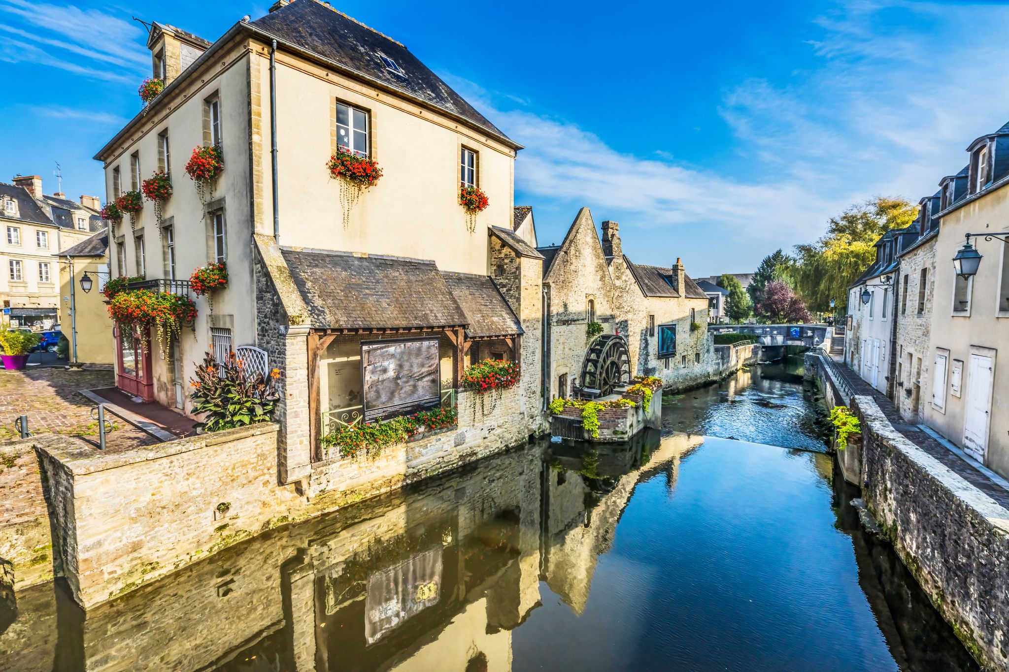 Photo of colorful old buildings, Aure river reflection, Bayeux, Normandy, France.