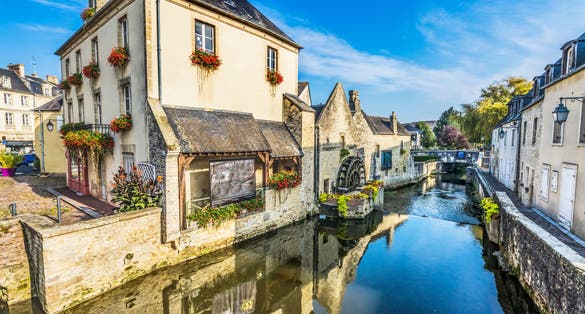 Photo of colorful old buildings, Aure river reflection, Bayeux, Normandy, France.