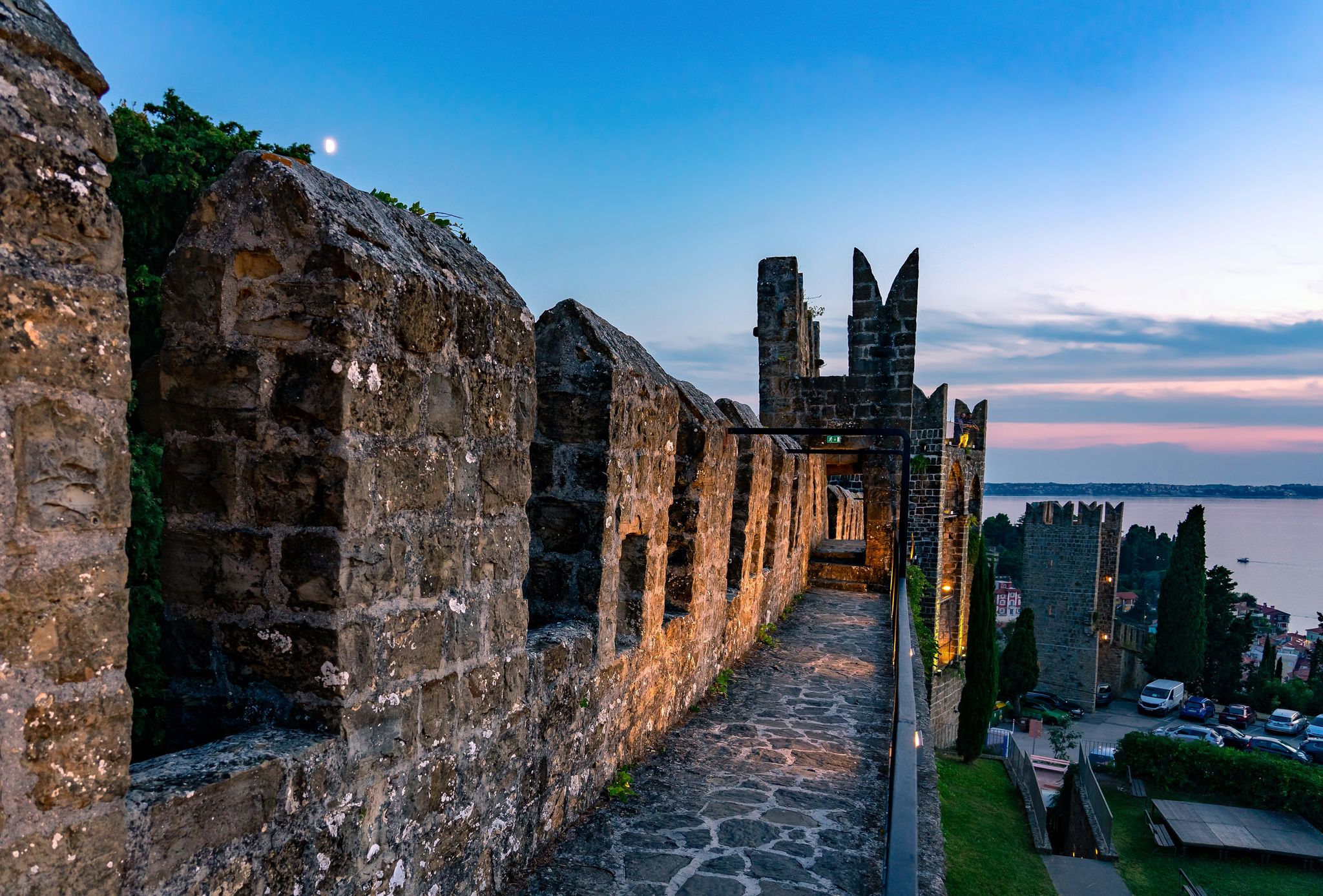 Illuminated City walls of Piran Piransko obzidje after sunset .