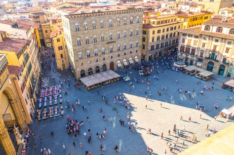 photo of Florence, Italy, September 15, 2018: Crowd of small figures of people are walking on piazza della signoria square in historical center, top view from palazzo vecchio palace