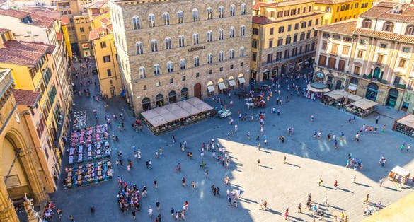 photo of Florence, Italy, September 15, 2018: Crowd of small figures of people are walking on piazza della signoria square in historical center, top view from palazzo vecchio palace